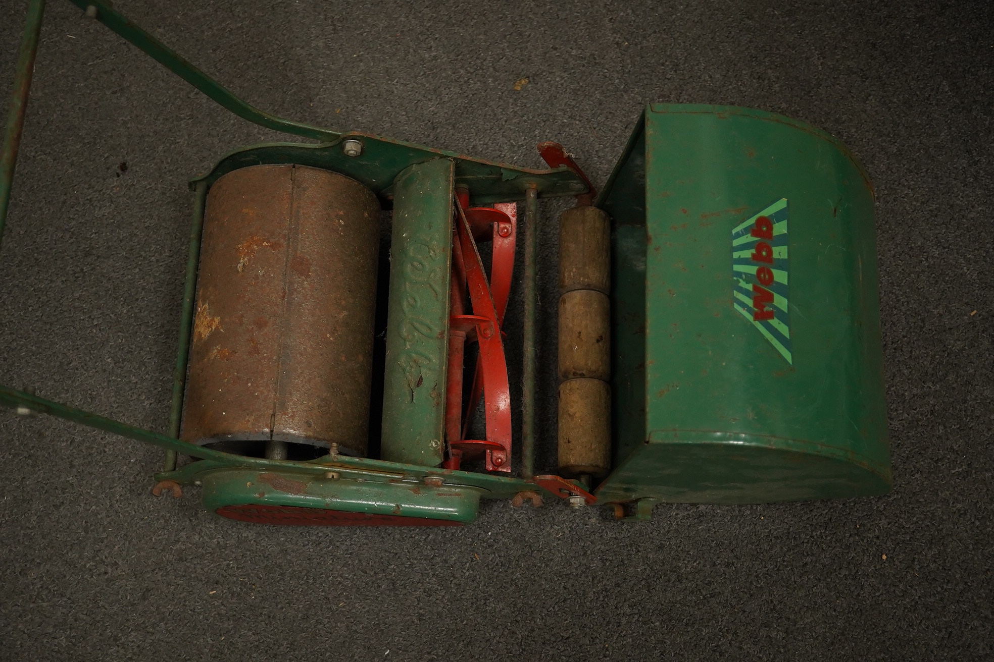 A late 1950s child's Webb push along scale model lawn mower, with Webb transfers to the grass box and side of the body and rubber handles, 63cm high. Condition - fair, some surface rust and general age related damage and